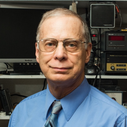 Charles Legg wearing a blue shirt and tie